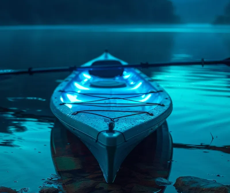 a mesmerizing shot of a kayak glowing with bioluminescent light on a dark, tranquil night.